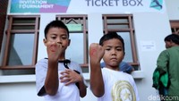 2 Anak menunjukan stempel di tangan mereka.