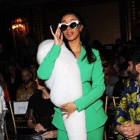 Cardi B dalam setelan blazer hijau. Ia menambahkan sentuhan high fashion dengan aksen bulu sebagai aksesori. Foto: Getty Images