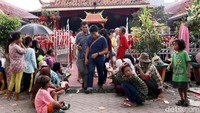 Mereka duduk di depan gerbang berharap mendapat angpao.
