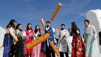 Sekelompok anak muda memakai pakaian tradisi Korea Selatan saat bermain game sambil merayakan Imlek
