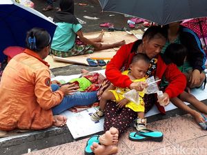 Gendong Anak, Ibu-ibu Berpayung Menanti Angpao di Petak Sembilan