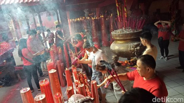 Warga Tionghoa membakar hio sebelum sembahyang.