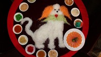 Sosok anjing kelihatan gagah dengan bulu lobak dan wortel. Pelengkap salmon, pangsit, wakame, wijen dan banyak lainnya disusun mengelilinginya. Foto: Istimewa