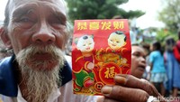 Seorang warga menunjukkan angpao yang diterimanya.