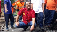 Saat meninjau jalan retak itu, Anies memakai baju khas China berwarna merah