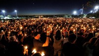 Warga menghadiri malam penyalaan llilin di sekolah Marjory Stoneman Douglas di Parland, Florida.