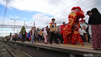 Barongsai beratraksi di antara penumpang commuter line.