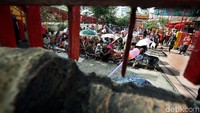 Sebagian warga memakai payung untuk melindungi diri dari panas terik matahari.