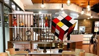 Berkonsep modern minimalis, kafe ini punya pajangan unik. Sebuah rubik besar yang bagian ujungnya dilekatkan ke meja dan beberapa benda kuno hingga action figure. Foto: Venture Capital Cafe