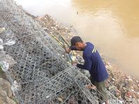 Petugas Gotong Royong Pasang Bronjong di Jalan Retak Kampung Berlan