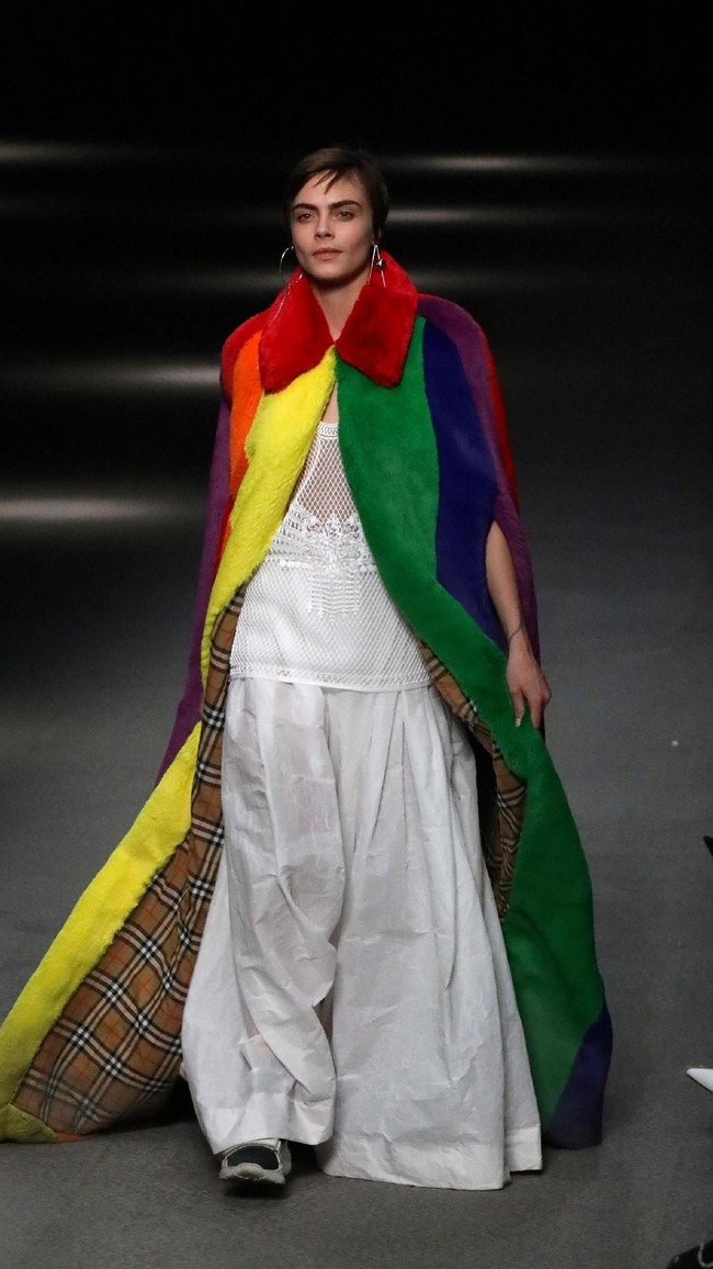 Ia menebar pesonanya dalam balutan gaun putih yang dibungkus dengan mantel bulu tebal berwarna pelangi. (Foto: REUTERS/Paul Hackett)