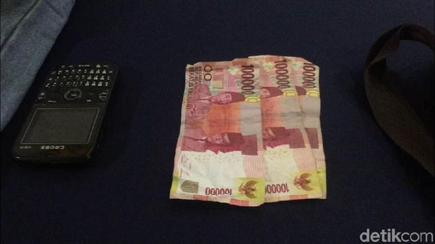 Barang bukti uang dan ponsel dari kasus pembunuhan dan penyiksaan di Pasar Rebo, Jaktim