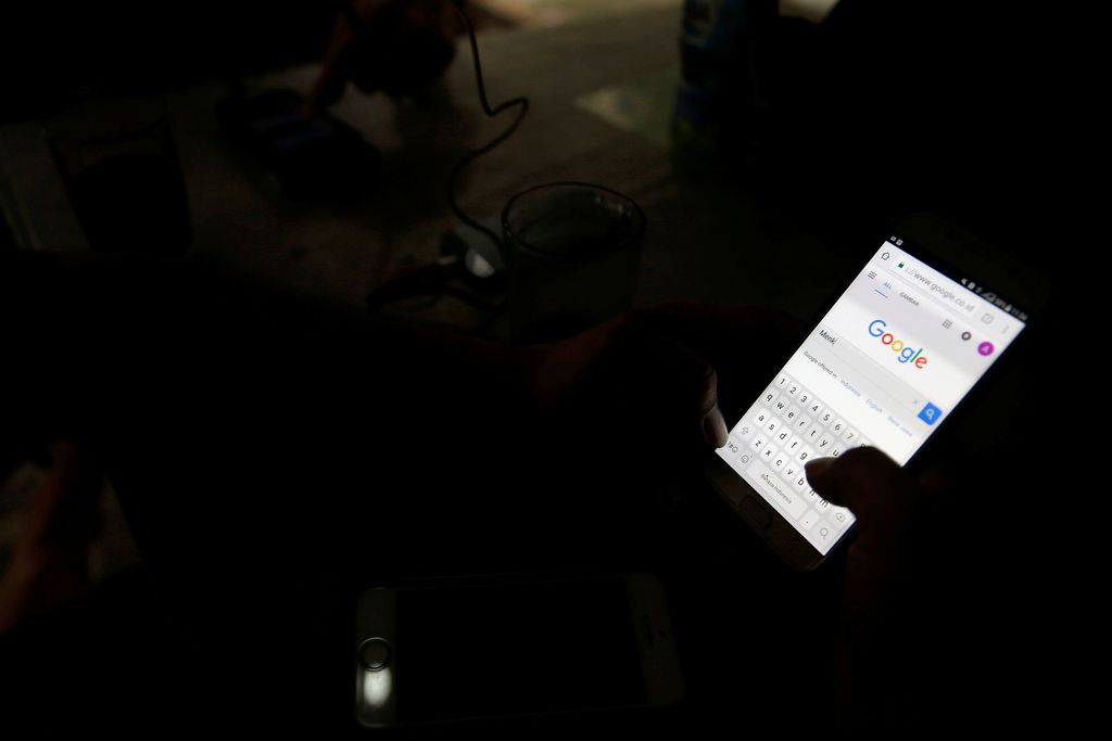 A man use his smartphone, in this picture illustration taken February 14, 2018. Picture taken February 14, 2018. REUTERS/Beawiharta/Illustration
