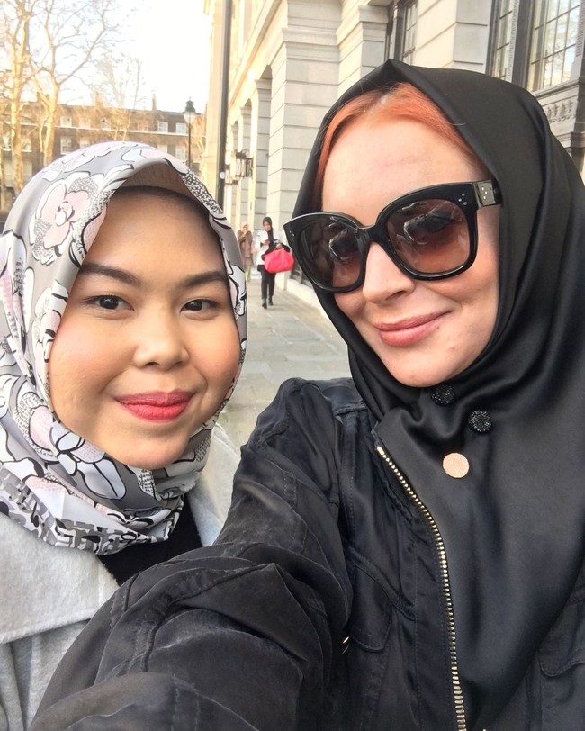 Lindsay Lohan terlihat memakai pashmina warna hitam berbahan satin. Tampilannya hari itu ternyata hasil tangan hijabers Indonesia bernama Tika Mulya. Tika bertugas menjadi fashion stylist di acara tersebut. Foto: Instagram