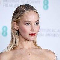 Gayanya kian sempurna berkat rona bibirnya yang merah menyala dengan riasan wajah natural, berikut hair-do yang wet-look. Tidak ketinggalan sepasang anting bermata zamrud berdesain simpel.  (Foto: Jeff Spicer/Getty Images)