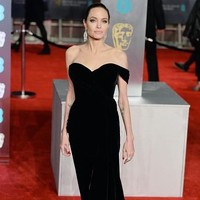 Angelina Jolie tak kalah menawan dari para juniornya. Di karpet merah BAFTAs 2018, pemain First They Killed My Father itu memilih gaun strapless dengan belahan tinggi dan bermaterial beludru dari Ralph and Russo. Foto: Getty Images