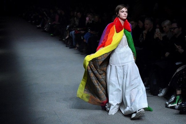 Tampak di balik mantel tersebut, motif plaid berrwarna putih-coklat khas Burberry. Adapun warna pelangi dipilih sebagai bentuk dukungan label Inggris tersebut terhadap komunitas LGBTQ (lesbian, gay, biseksual, Transgender, Queer). (Foto: AFP PHOTO / Ben STANSALL)