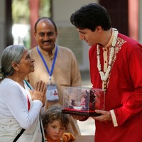 Justin Trudeau memakai kurta merah, sejenis baju tunik khas India yang dihiasi gota (bordiran) berwarna emas di hem lengan dan kerah. Putra tertuanya, Xavier, juga memakai kurta yang sama. Foto: Reuters