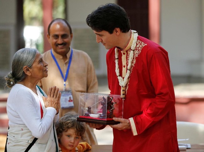 Justin Trudeau memakai kurta merah, sejenis baju tunik khas India yang dihiasi gota (bordiran) berwarna emas di hem lengan dan kerah. Putra tertuanya, Xavier, juga memakai kurta yang sama. Foto: Reuters
