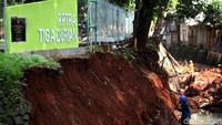 Sejumlah pekerja sedang memperbaiki turup RPTRA yang longsor.