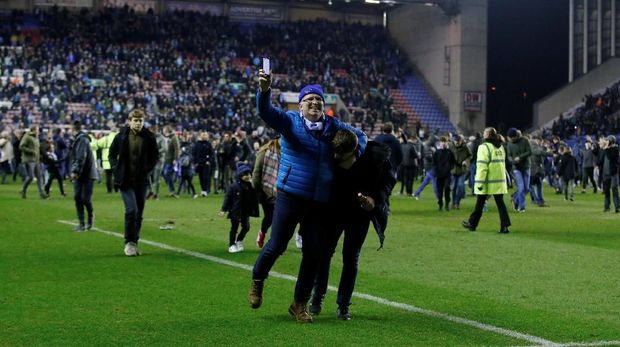 Suporter Wigan masuk ke lapangan usai Manchester City kalah.