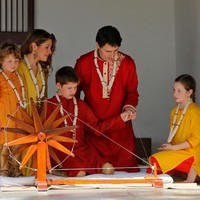 Mencoba alat tenun untuk membuat kain katun. Mereka terlihat sangat antusias. Foto: Reuters