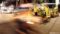 Seorang petugas Sudin Bina Marga Jakarta Pusat mengatur lalu lintas di sekitar lokasi perbaikan jalan.