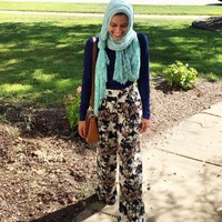 Tahera Rahman biasanya memakai hijab berupa pashmina simple yang direkatkan di bawah dagu kemudian dirapikan di bagian bahu. Ciri khasnya adalah pashmina yang dibuat simpul di satu sisi saja. Foto: Instagram/TaheraTV