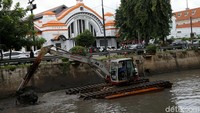Alat berat mengeruk lumpur yang mengendap.