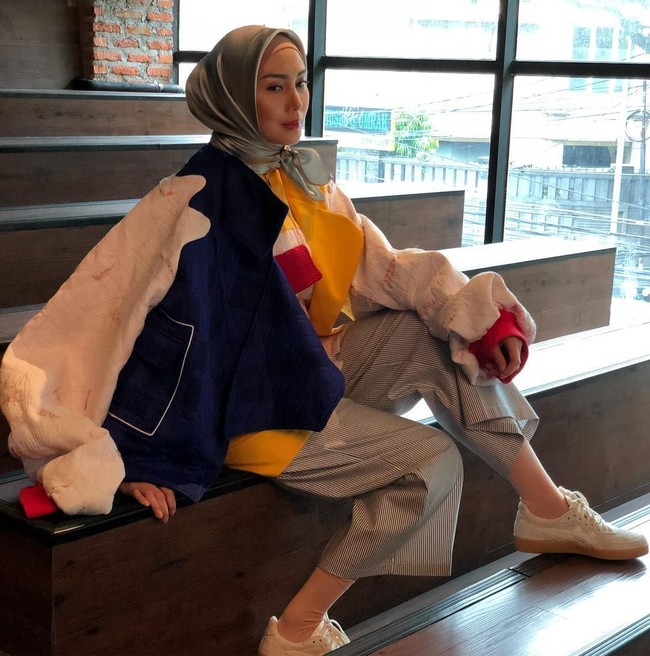 Busana oversized juga jadi pilihan yang tepat untuk hijabers. Selain terlihat stylish, busana oversized menutupi lekukan tubuh sehingga terlihat lebih sopan. Fenita Arie memilih atasan oversized dengan bloking warna yang keren.Foto: Instagram