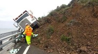 Sopir truk ini sangat beruntung ketika mobilnya terdorong tanah longsor bisa tertahan oleh pembatas jalan. Foto: boredpanda