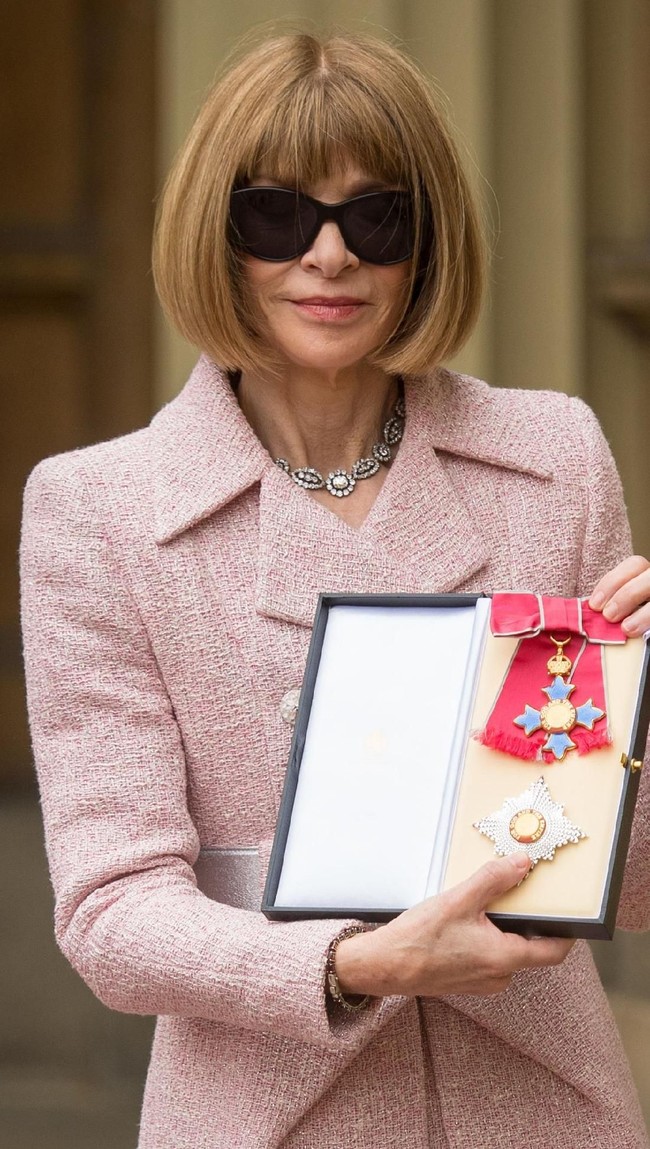 Ratu Elizabeth II pernah bertemu dengan Anna Wintour setahun silam saat memberikan gelar kehormatan Dame padanya. Tentu saja kacamata hitam tidak diperkenakan saat prosesi berlangsung. Anna kembali memakainya saat berpose di hadapan para fotografer di luar. (Foto: Getty Images)
