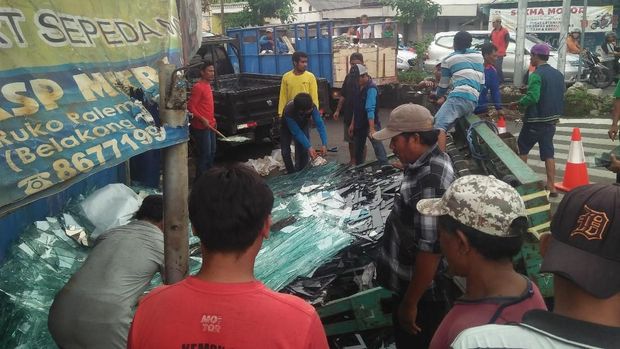 Warga membersihkan kaca yang pecah berhamburan