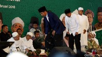 Jokowi hadir dengan mengenakan jas, sarung, dan peci warna hitam.