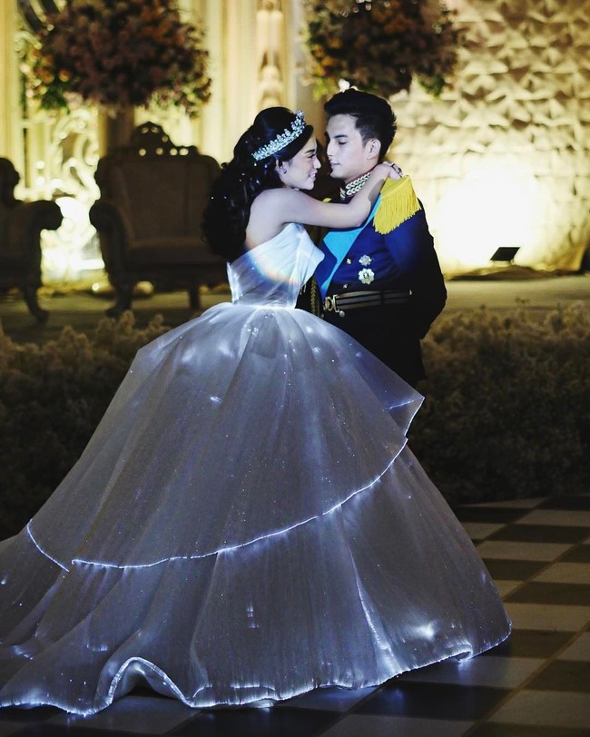 Sesuai tema pesta, Niko dan Rachel pun tampil seperti pangeran dan putri raja. Pada hari pernikahannya, selebgram dengan followers lebih dari 1,8 juta itu mengenakan gaun pengantin megah yang bisa menyala dalam gelap. Gaun glow in the dark yang dikenakan Rachel merupakan rancangan Yogie Pratama. Foto: Instagram