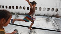 Anak-anak kecil dari keluarga yang mendiami bangkai pesawat tampak bermain-main di sayap pesawat (Foto: Dok. REUTERS/Soe Zeya Tun)