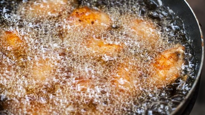 Close up image of cooking chicken in deep fry
