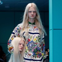 Namun bukan itu saja yang membuat peragaan ini lain daripada yang lain. Terlihat model perempuan dalam balutan blus motif floral berlenggang sambil menenteng kepalanya sendiri. Wajah keduanya sangat mirip. (Foto: REUTERS/Tony Gentile)