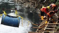 Pekerja tengah menyelesaikan pengerjaan tanggul di sepanjang anak Kali Ciliwung, Jakarta, Kamis (22/2/2018).