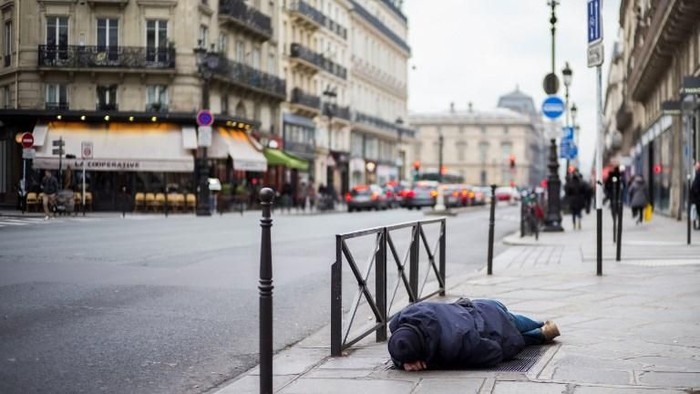 (FILES) In this file photo taken on January 16, 2017 a homeless man sleeps on the pavement in Paris as a cold wave is expected to hit France during the next days. 
Near 3,000 homeless people were accounted for in Paris on February 15 and February 16, 2018 during a census to estimate the size of the homeless population, according to the Paris city hall on February 21, 2018. / AFP PHOTO / MARTIN BUREAU