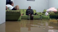 Nampak mereka duduk di sopa yang sebagiannya basah karena terendam banjir.