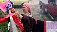 Seorang pencari suaka tengah menjemur pakaian di lahan milik warga setempat.