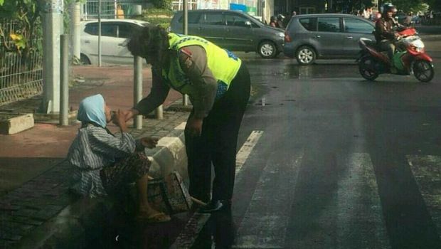 Aiptu Chaterina Yani memberi makan ke nenek-nenek yang kelelahan di bawah lampu merah