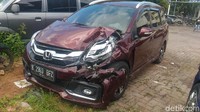 Kondisi mobil itu ringsek di bagian depan. Bagian sisi kiri kap mobil itu penyok di sana-sini.