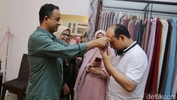 Anies memakaikan kaca mata ke Novel