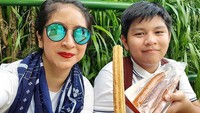 Bersama sang putra, Angie juga kompak nih. Mereka makan churros yang jadi camilan wajib saat ke Disneyland. Foto: Instagram novitaangie