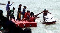 Seorang pengendara jetski tampak menyapa sejumlah anak-anak dari tepi dermaga.
