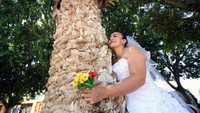 Ada pula wanita lain yang juga memakai baju pengantin. Tentu saja, aksi menikahi pohon ini bukan menikah betulan.