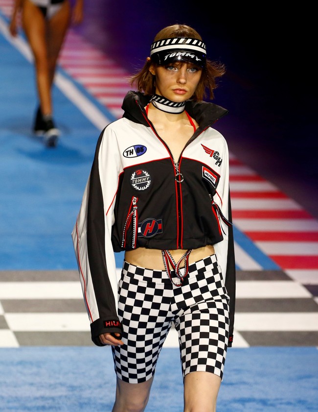 Panggung runway diubah jadi arena balap bernuansa Formula 1. Tak hanya menonton fashion show, undangan juga bisa berfoto dengan instalasi mobil-mobil balap dan tumpukan ban. Foto: Reuters