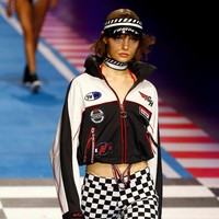 Panggung runway diubah jadi arena balap bernuansa Formula 1. Tak hanya menonton fashion show, undangan juga bisa berfoto dengan instalasi mobil-mobil balap dan tumpukan ban. Foto: Reuters
